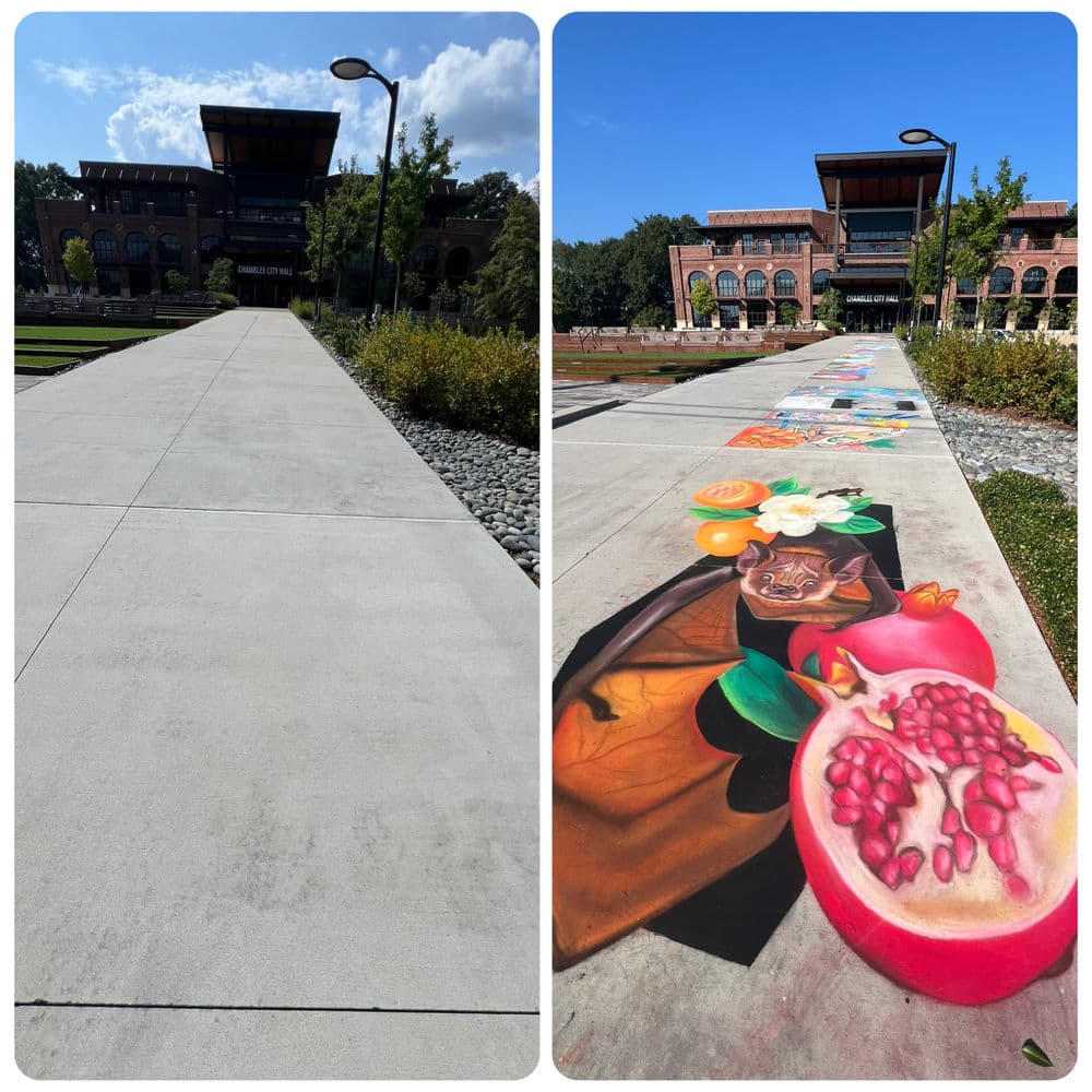 Colorful mural featuring fruits on a sidewalk leading to a building under a blue sky.