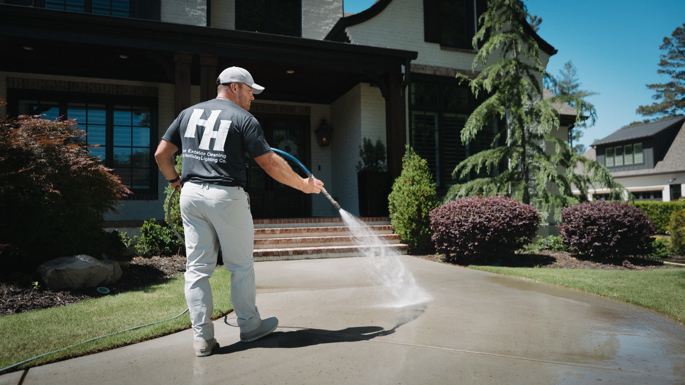 Jordan from Horizon Hygiene pressure washing a driveway in front of an Atlanta-area home
